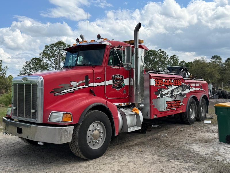 Close view of the red Peterbilt heavy wrecker door lettered with 239-404-0558 and DOT 4544870